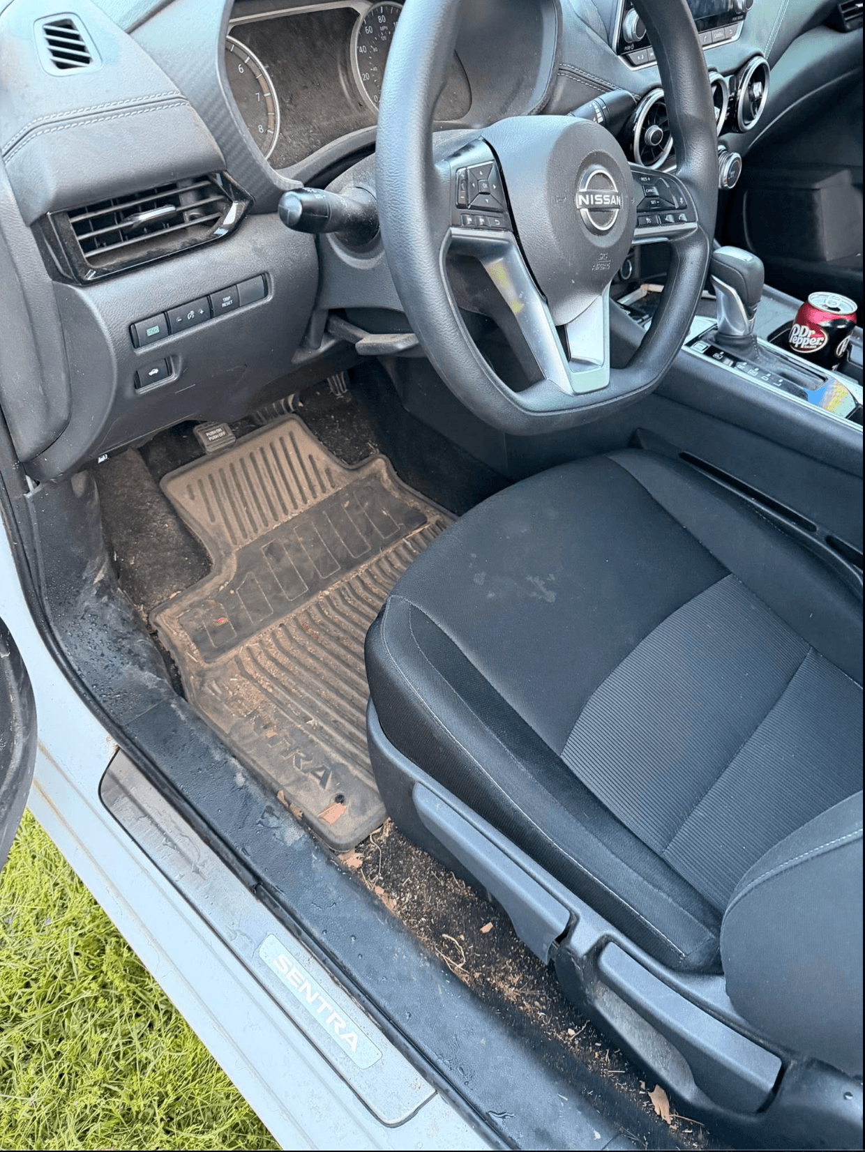 Nissan Sentra driver-side floor mat caked in mud and dirt before interior detail